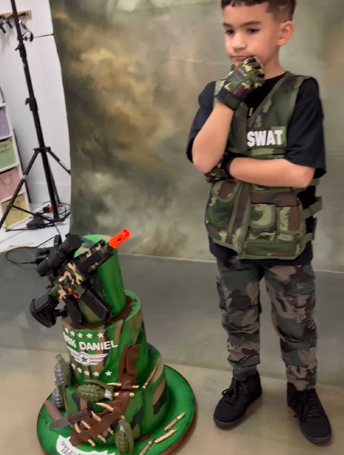 A child in a SWAT shirt and camo pants poses with a toy gun next to a green toy dinosaur in multiple action shots.