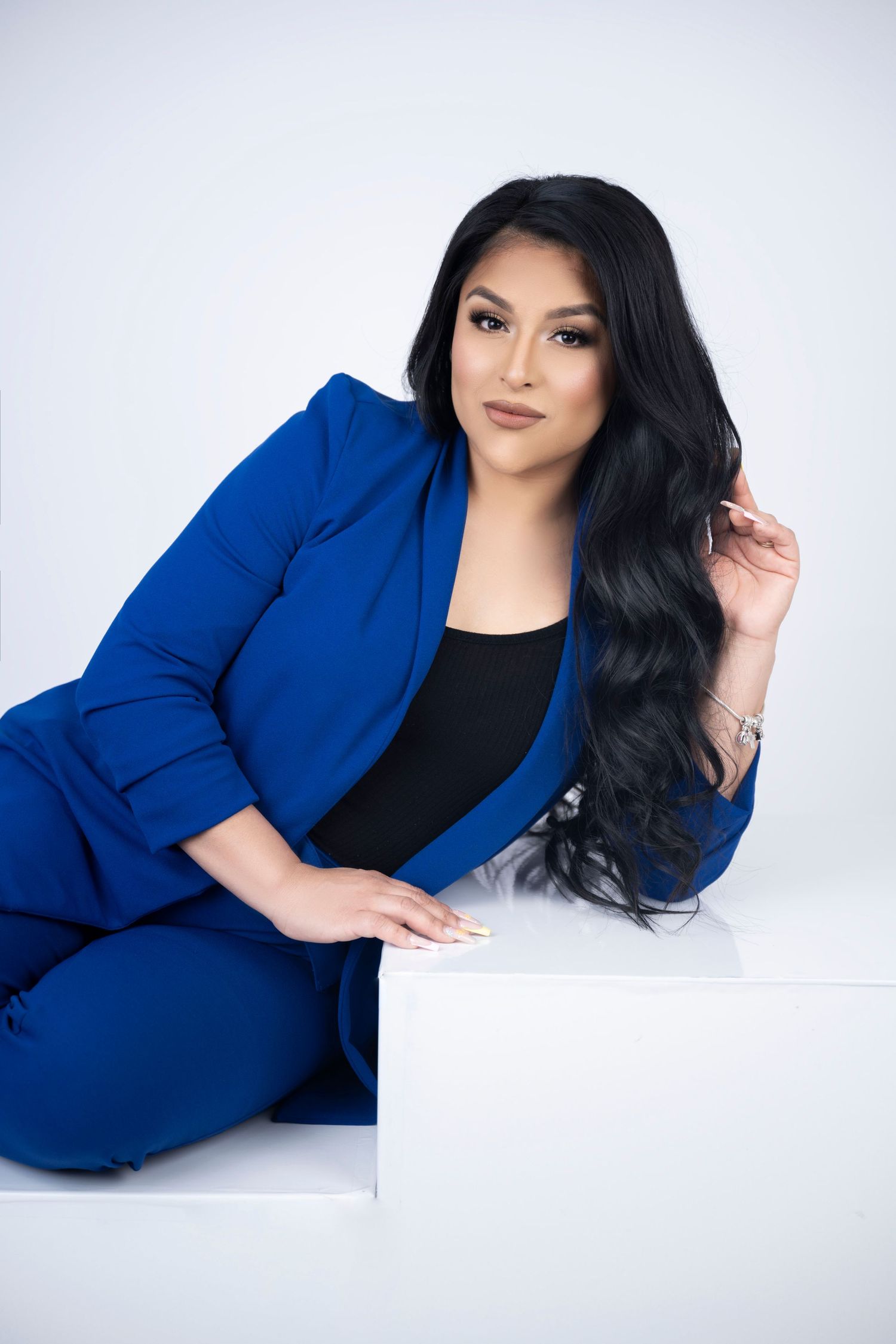Professional portrait featuring royal blue power suit against white background.