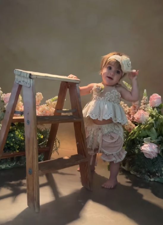 A sequence of five photos shows a baby doll positioned in different playful poses under a small wooden ladder.