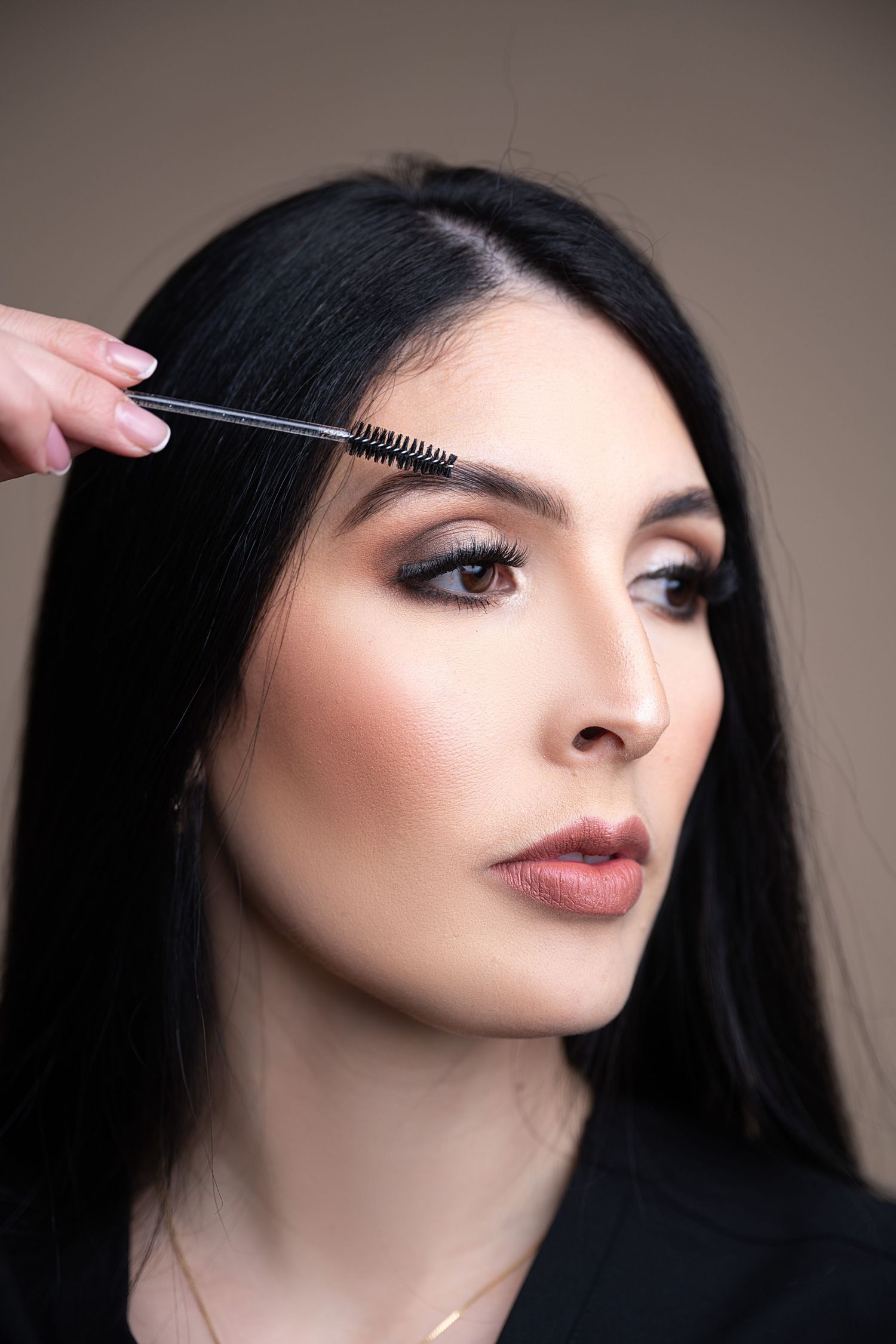 Close-up beauty shot demonstrating eyebrow grooming technique.