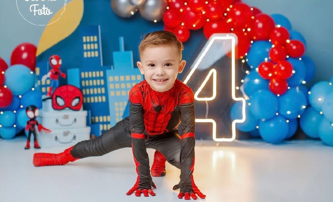 A birthday party setup with Spider-Man themed decorations including red and blue balloons and number candles.