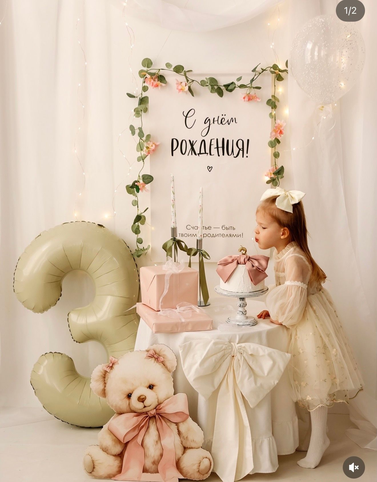 A little girl celebrates her 3rd birthday with a teddy bear, balloon number 3, and a decorated table with a Russian birthday sign.