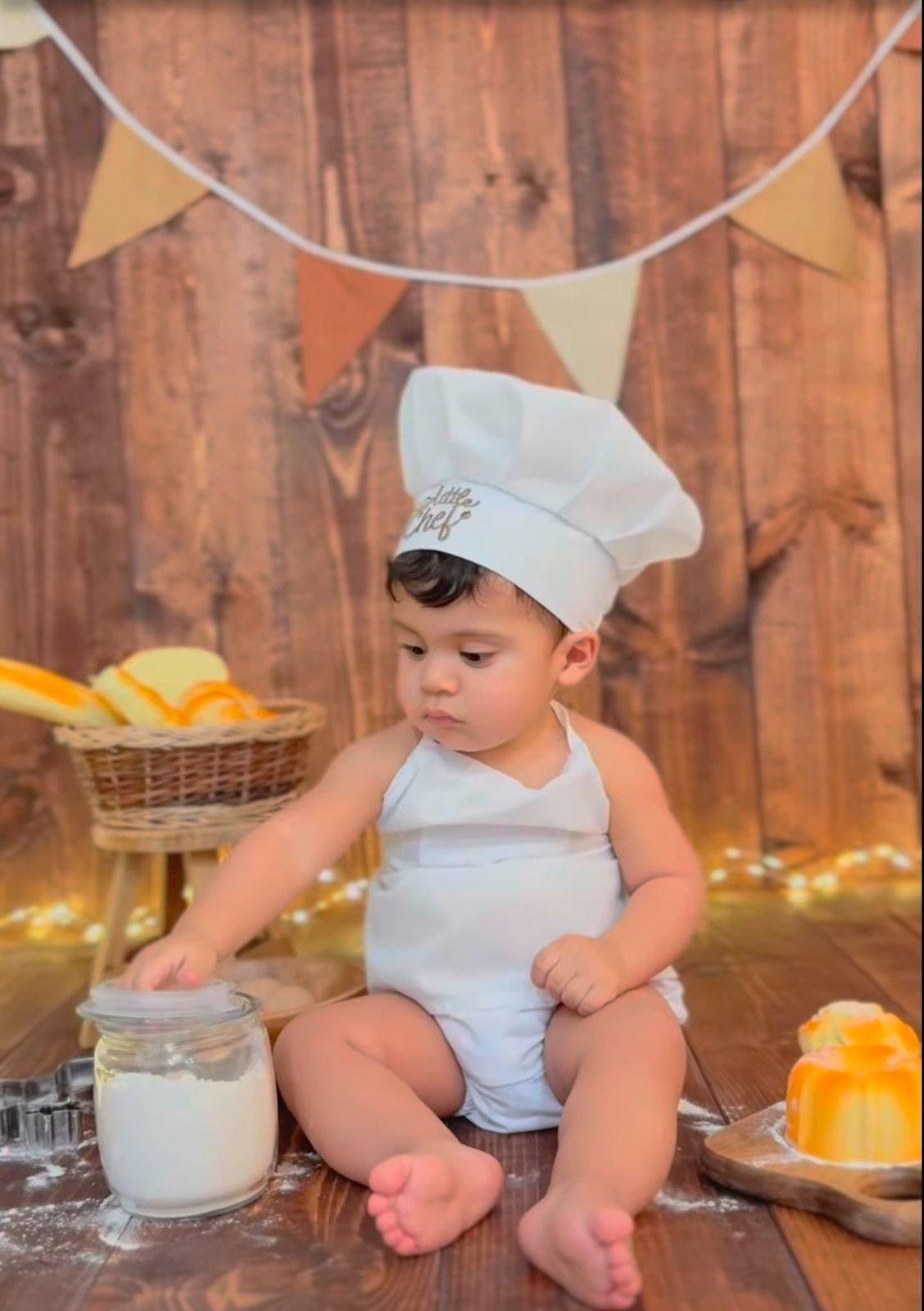 Baby chef photo with mixing ingredients and citrus fruits on rustic wooden table.