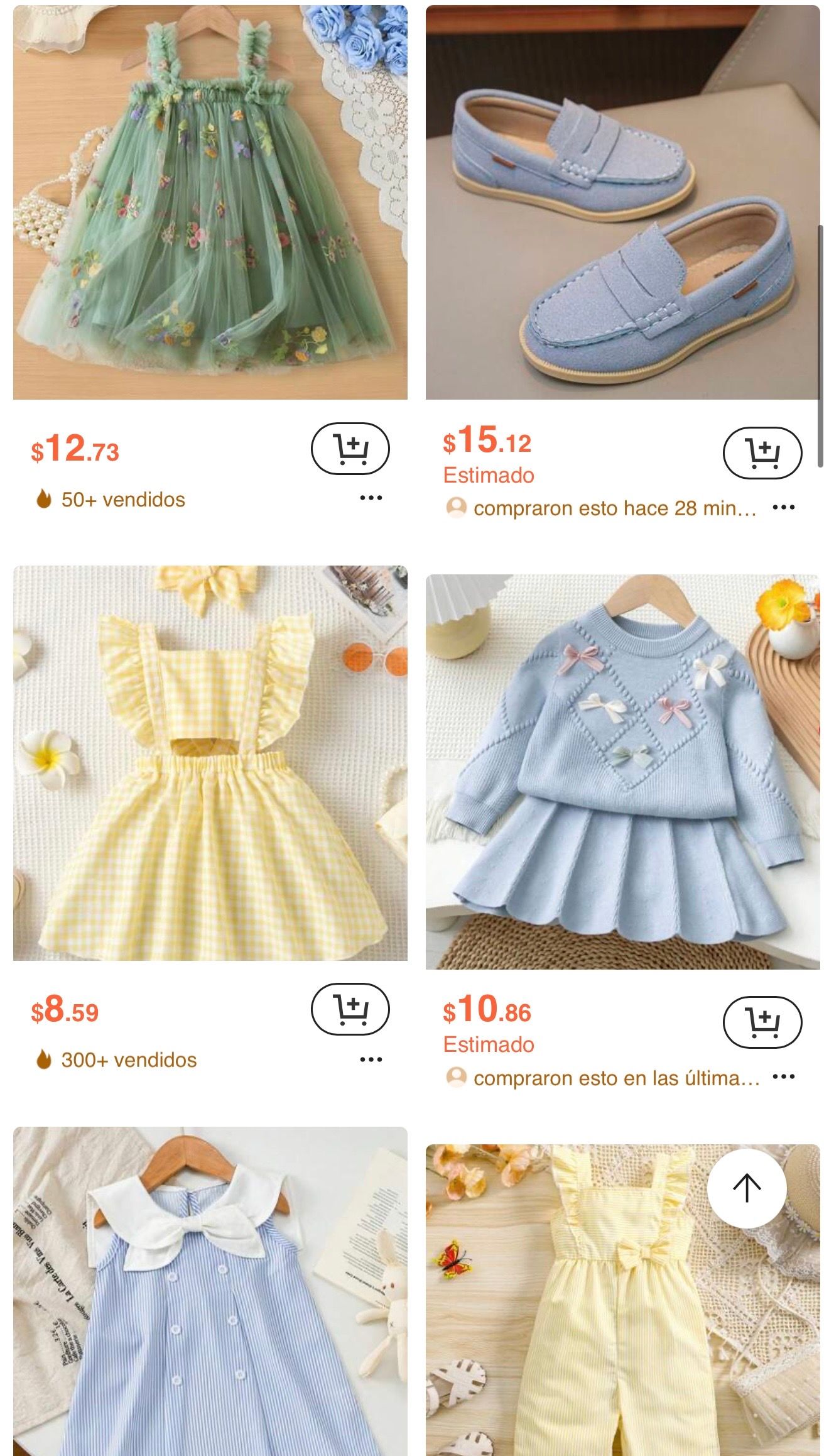Collection of pastel blue and yellow baby dresses and shoes with delicate embroidery and lace details in vintage style.