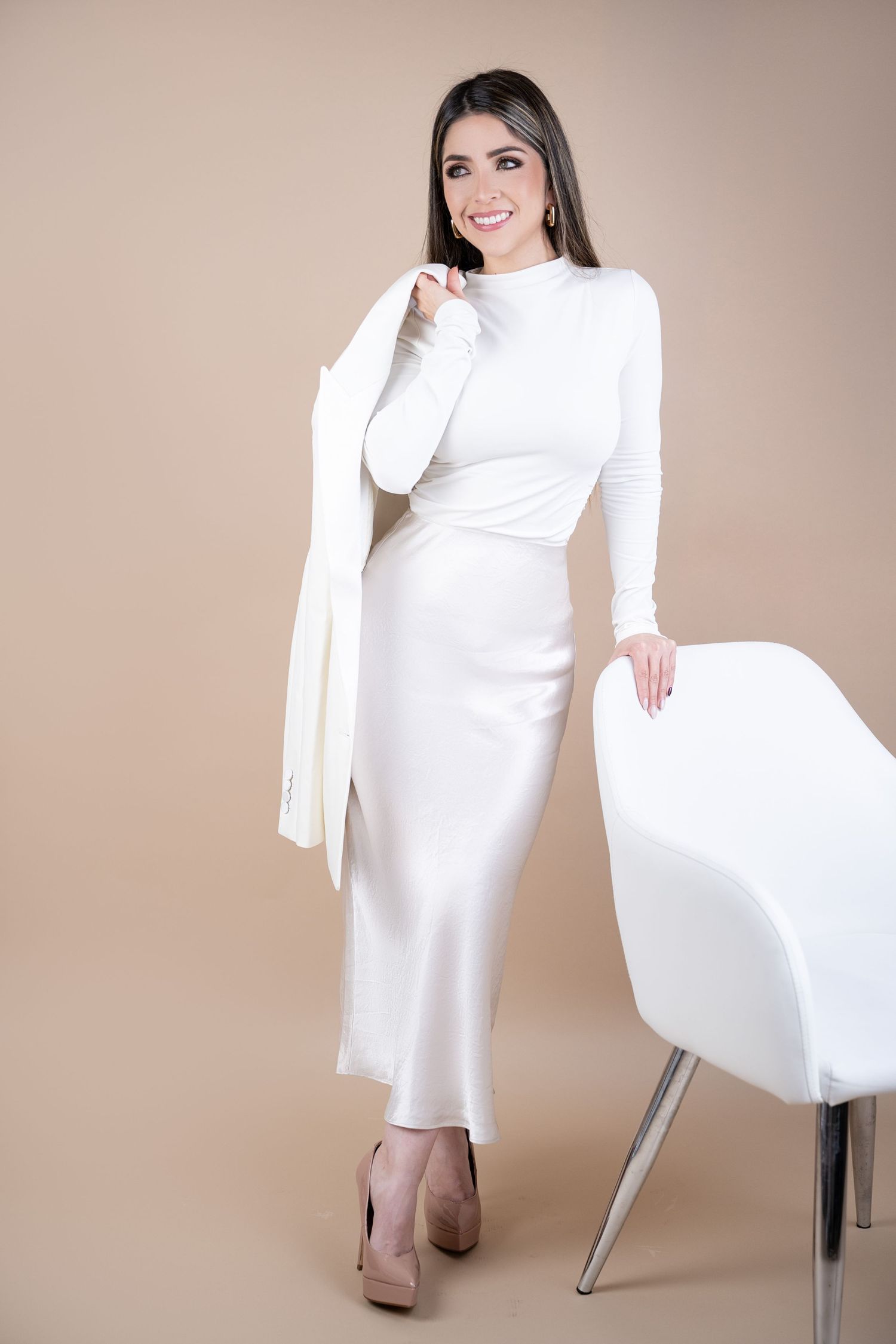 Stylish all-white ensemble with a fitted dress and blazer paired with nude heels.