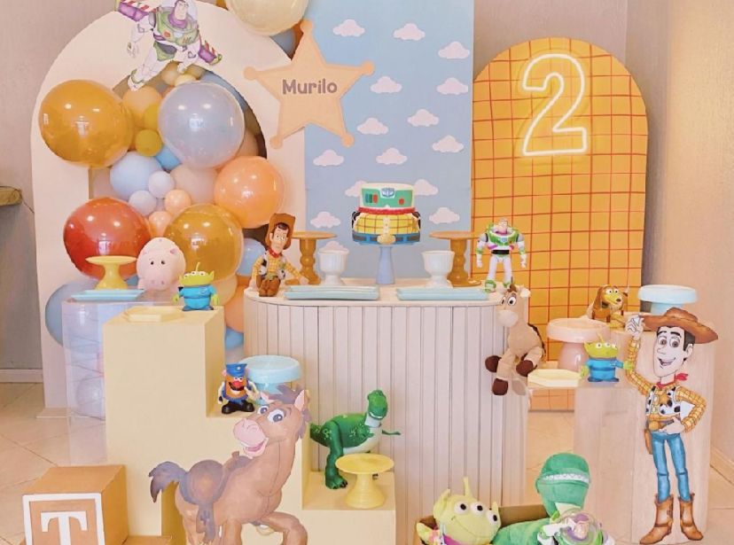 Toy Story themed birthday party setup with balloons, decorations and treats in pastel colors.