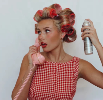 Vintage-inspired styling sequence showing hair being set with rollers and hairspray in a red gingham outfit.