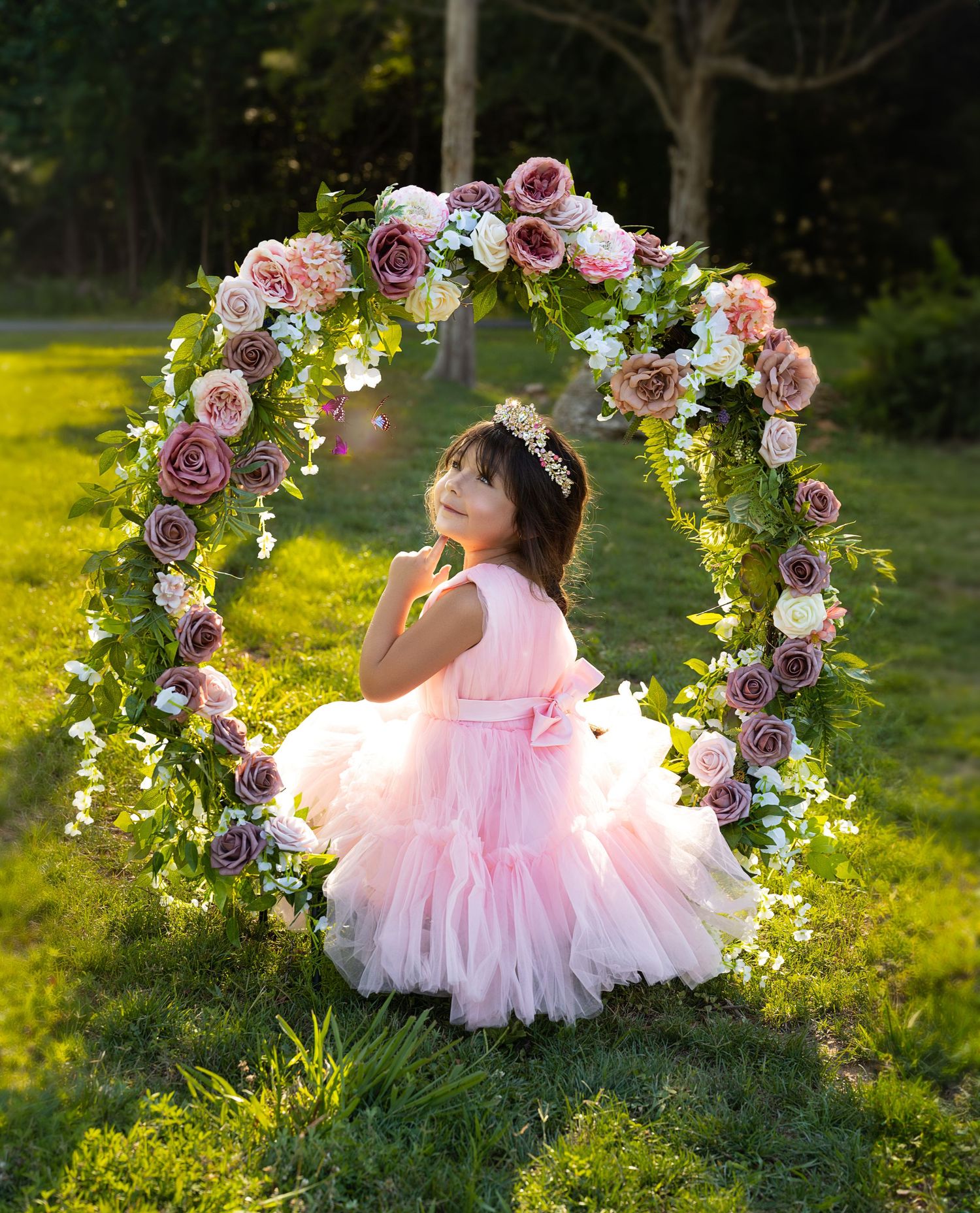 Beautiful rose-covered arch creates romantic frame in sunlit garden setting.