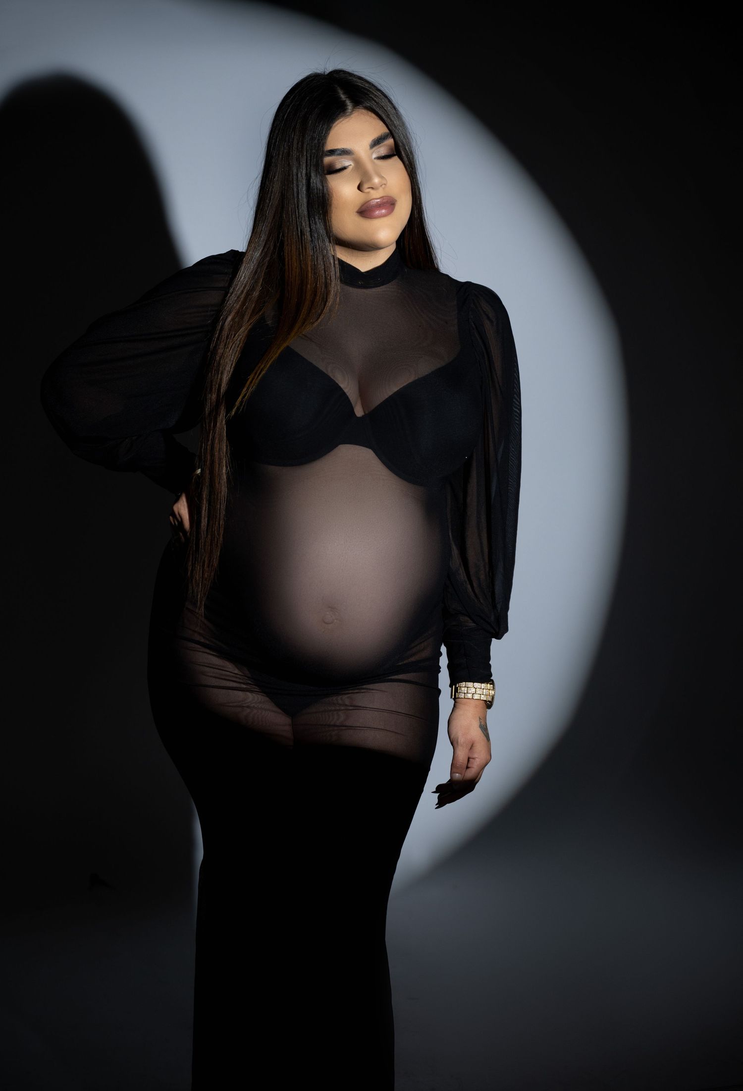 Dramatic studio portrait series featuring a figure in black clothing against a dark background with selective lighting.