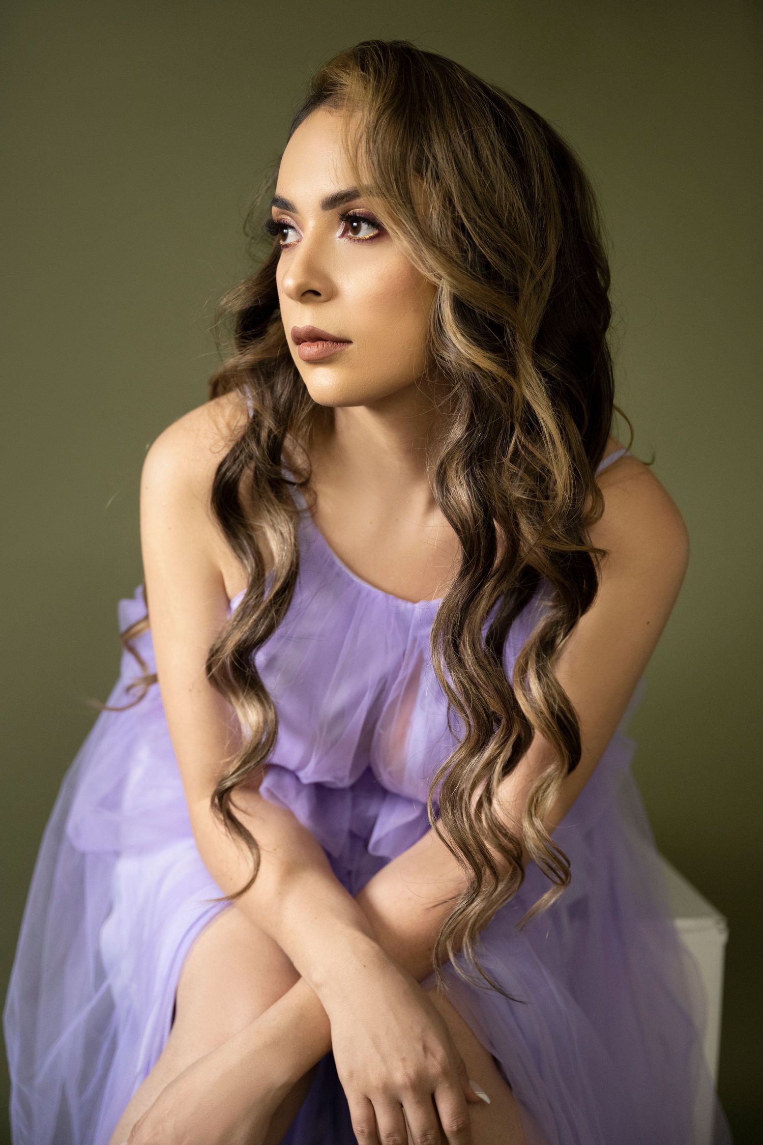 Soft portrait in flowing purple dress with romantic waves and neutral makeup.