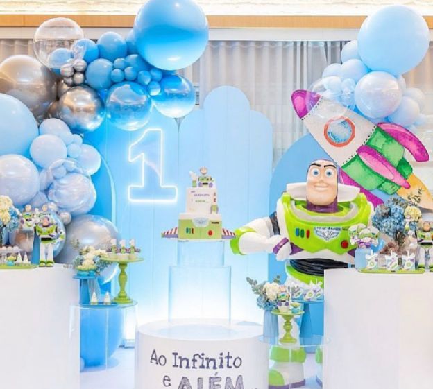 Blue and white balloon decorations with Toy Story theme elements create a festive party atmosphere.