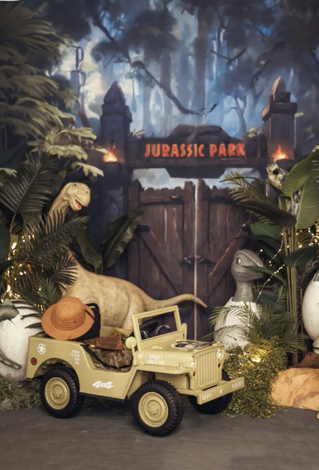 Decorative Jurassic Park themed display featuring vintage-style safari jeeps and tropical foliage against a moody backdrop.