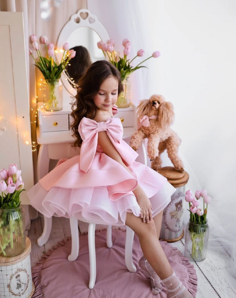 Dreamy pink and white photo setup with flowers, stuffed animals, and delicate decor elements.