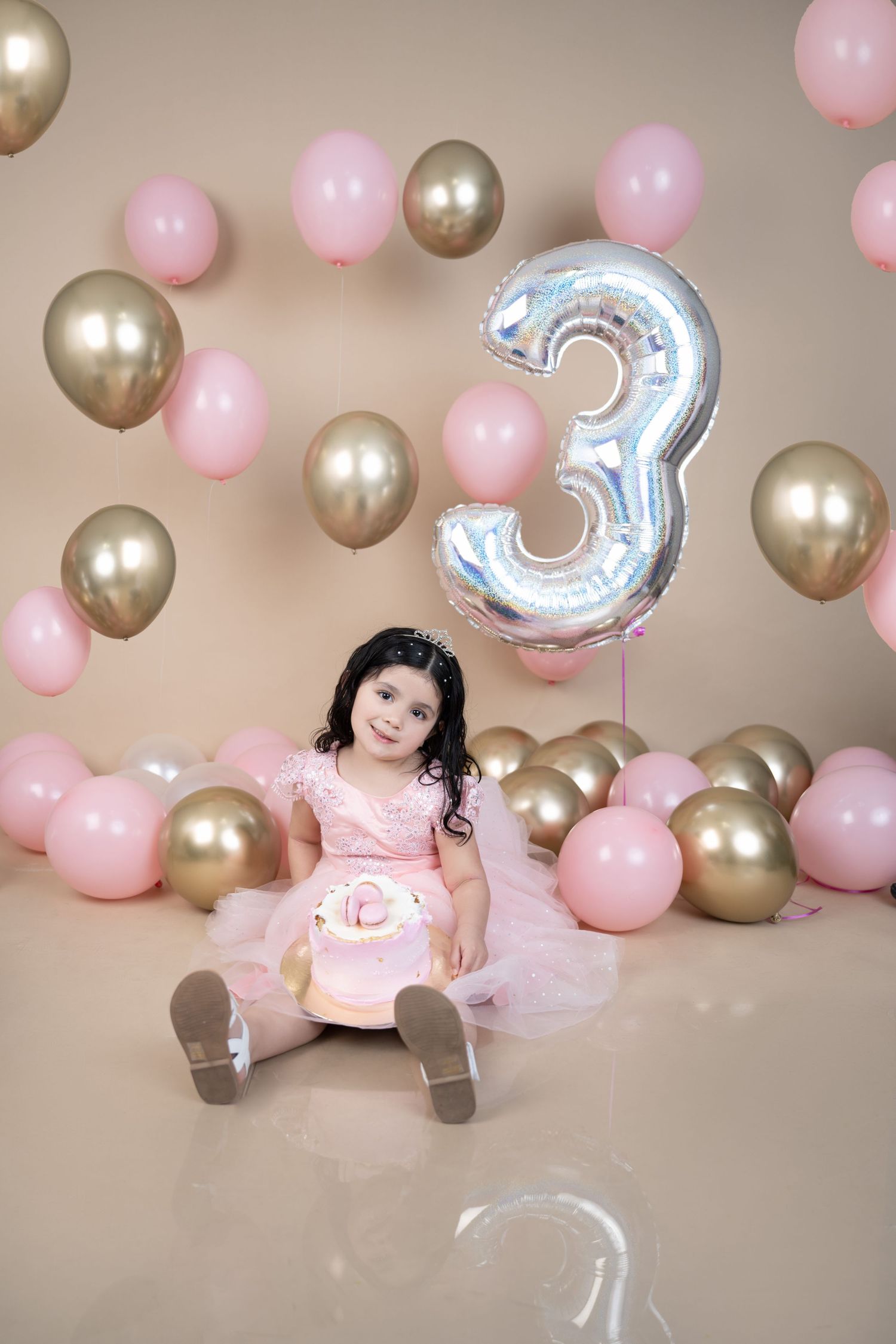 Birthday celebration setup with number 3 balloon and pink and gold balloon decorations.