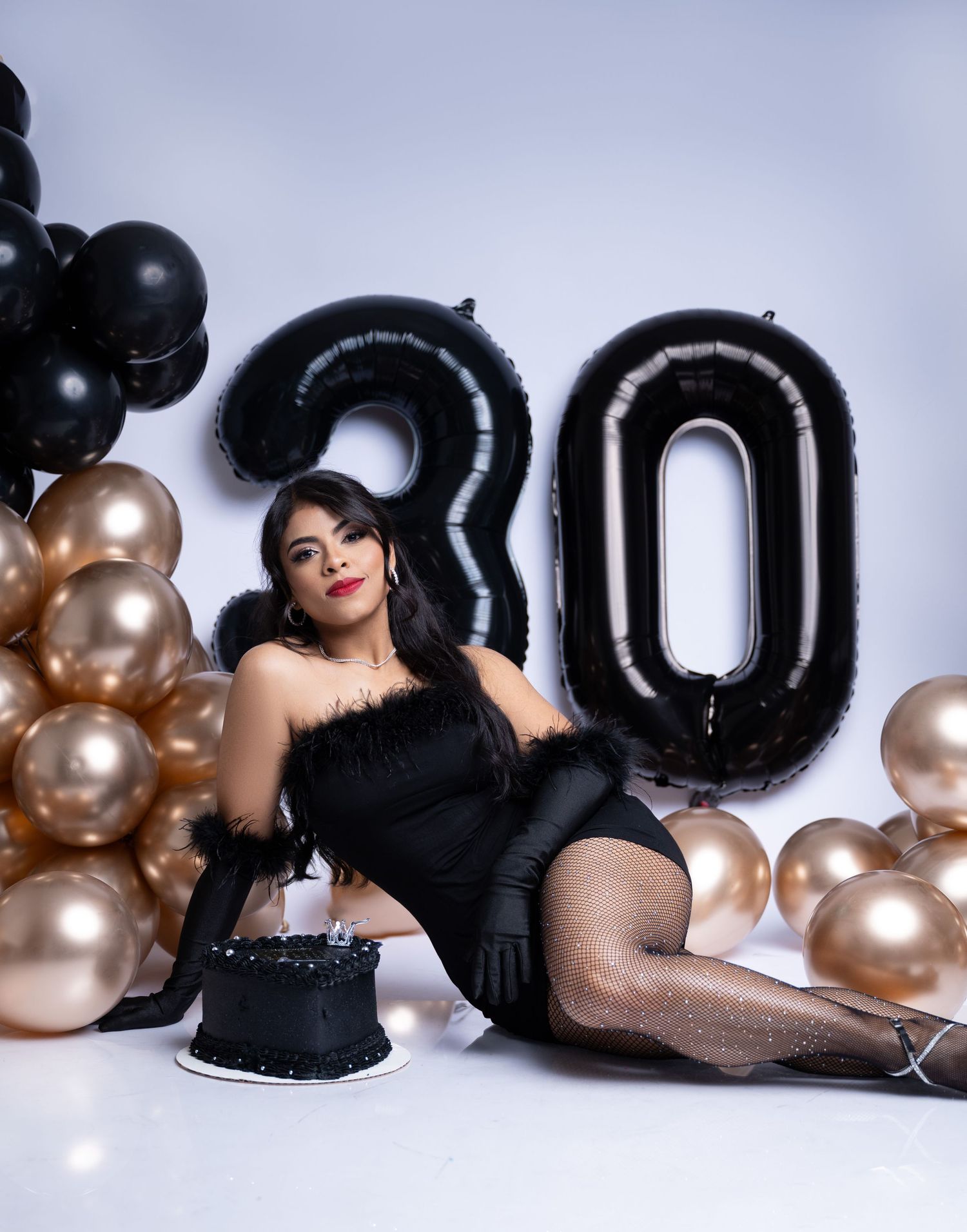 Birthday celebration setup with black '30' balloons and gold balloon decorations.