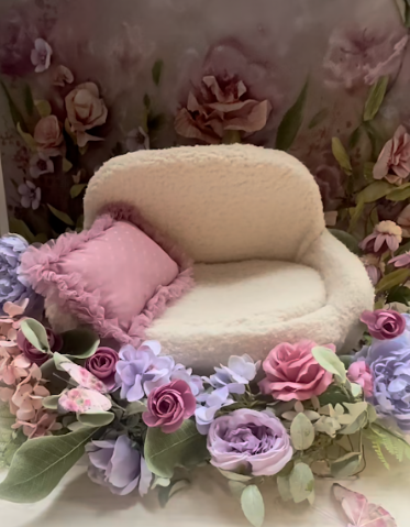 A delicate floral crown made with pink and purple roses, hydrangeas, and greenery arranged in a romantic style.