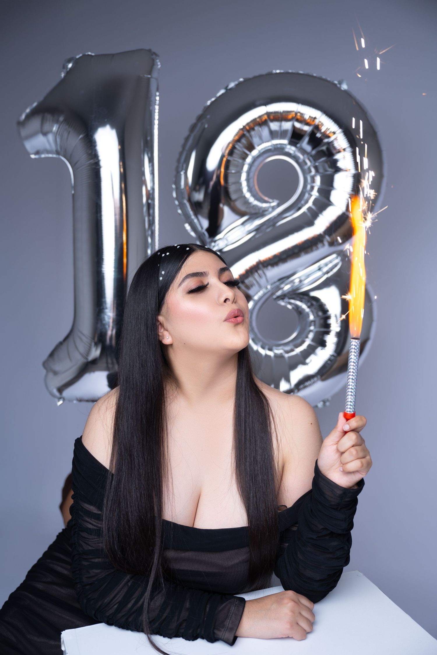 Birthday celebration setup with silver number 18 mylar balloons and festive decorations.