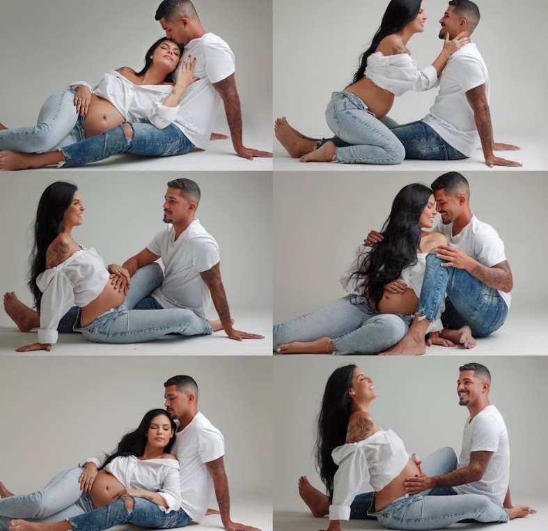 Couple in white and denim outfits playfully posing together in a studio setting with a light gray background.