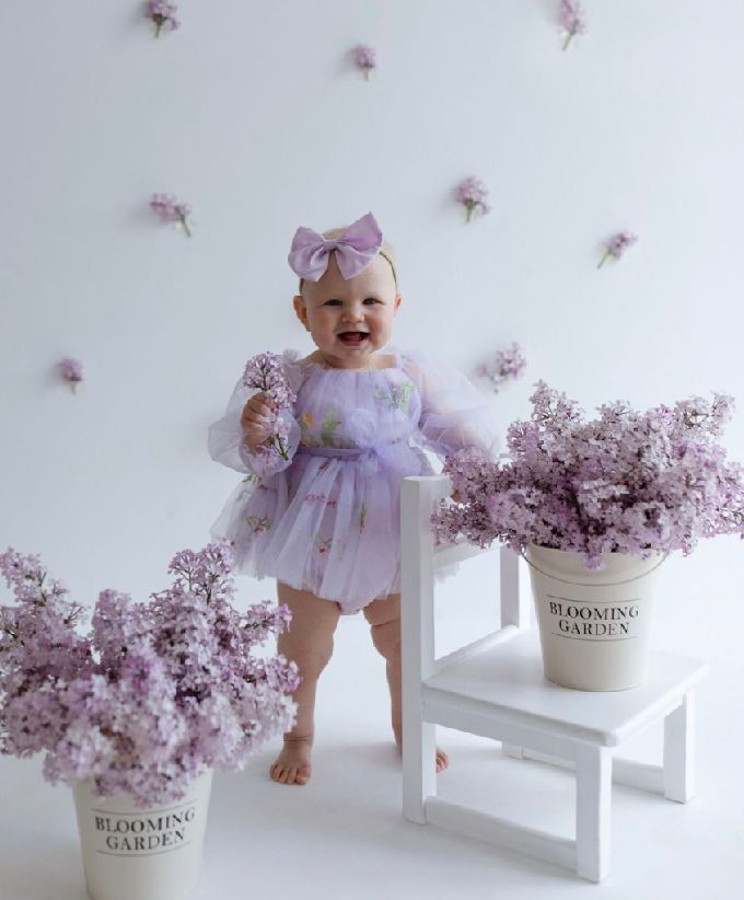 Delicate lavender flowers arranged in white ceramic pots alongside a small white bench create a soft, dreamy scene.