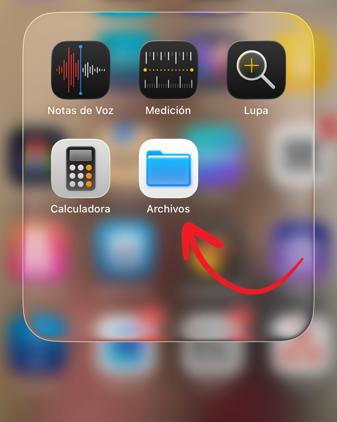 iPhone screen showing iOS app folder with Voice Memos, Measure, Magnifier, Calculator, and Files apps highlighted by red arrow.