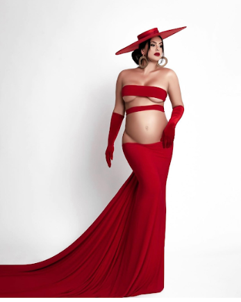 Maternity photoshoot series featuring a flowing red dress against a white backdrop creating an elegant silhouette.