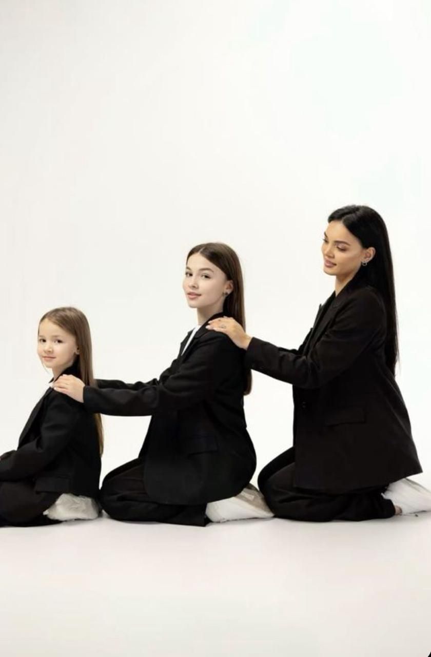 Multiple figures in black business attire sit in a row against a white backdrop creating a minimalist composition.