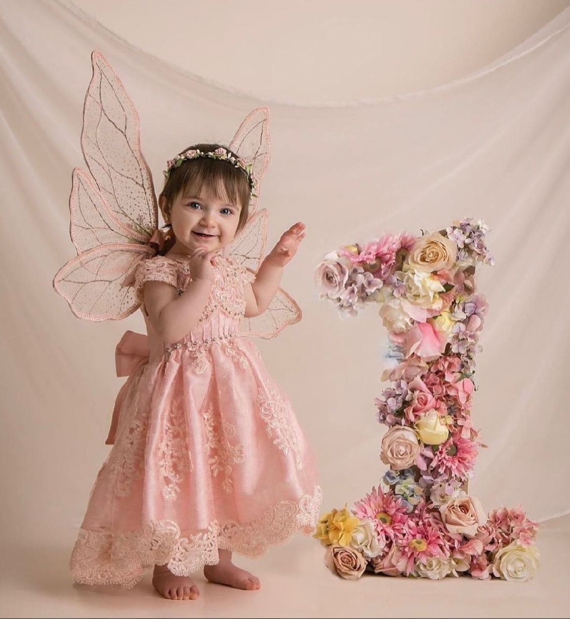 A floral number one decoration with pink and pastel flowers against a light backdrop.