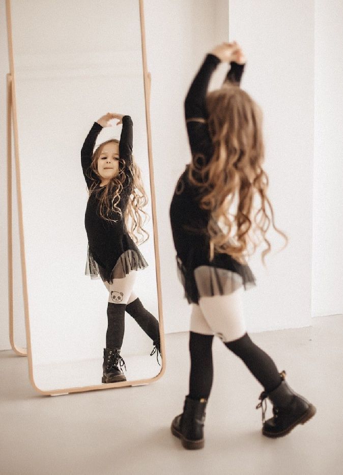A series of five dance poses showing dynamic movement in black clothing against a white studio backdrop.