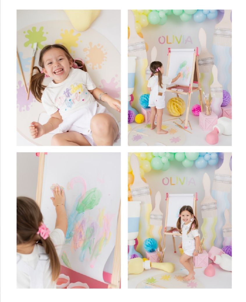 Pastel colored art themed photo session setup with balloons, easel and decorative elements in soft pink and blue tones.