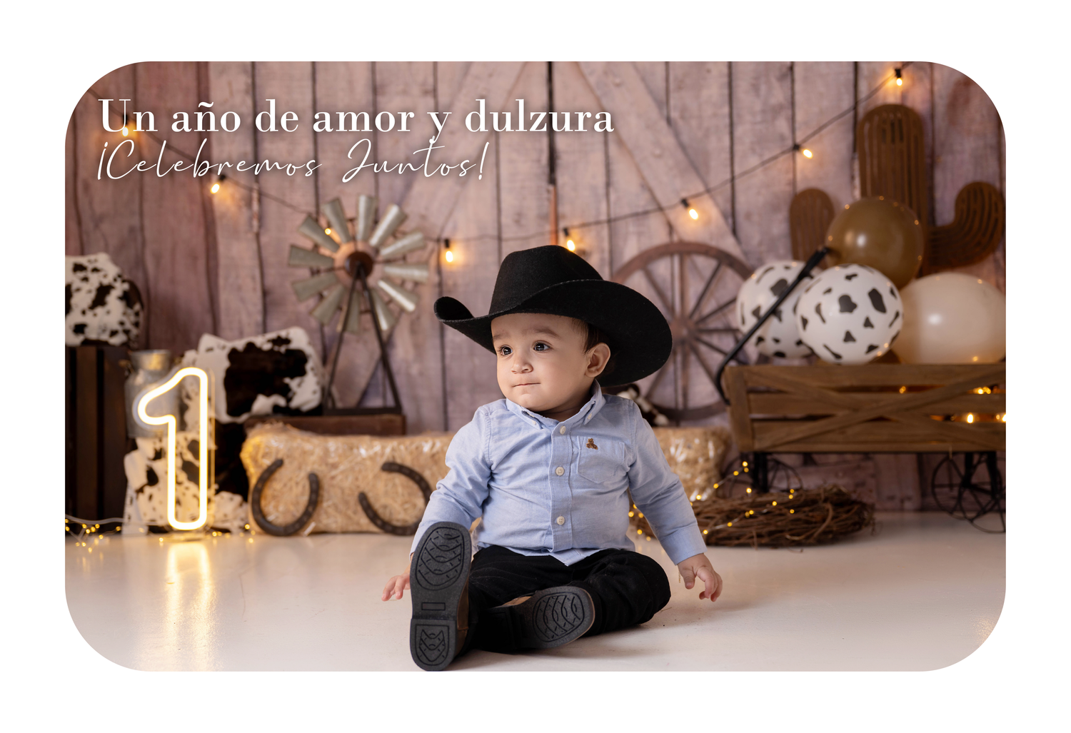 Baby boy in cowboy hat sits before a festive first birthday backdrop with Spanish text and rustic decor.