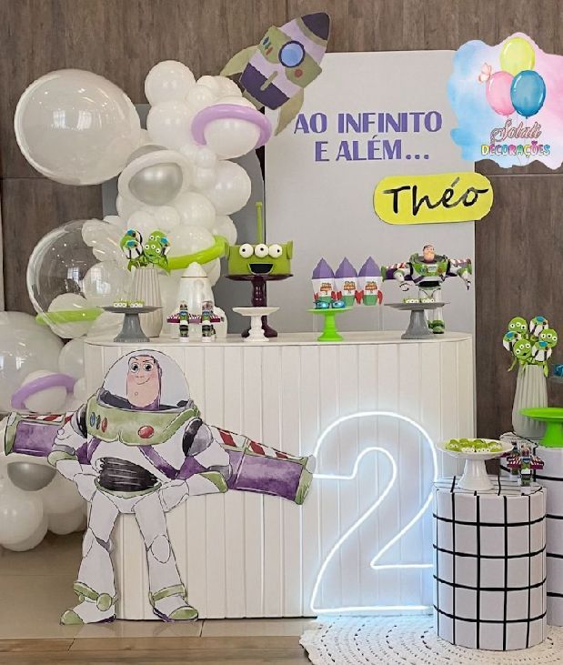 Modern Toy Story party display with neon number 2, white balloons, and character decorations.