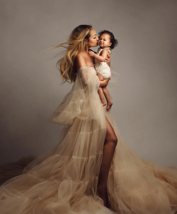 A figure in a flowing cream tulle gown spins gracefully in a series of dynamic dance-like poses against a neutral backdrop.