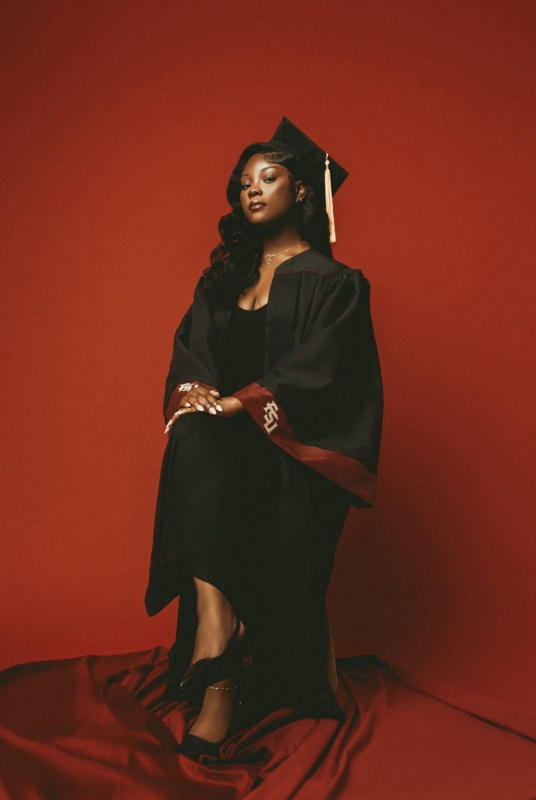 Artistic fashion portrait series against red backdrop showing dramatic poses in flowing black garments and elegant styling.