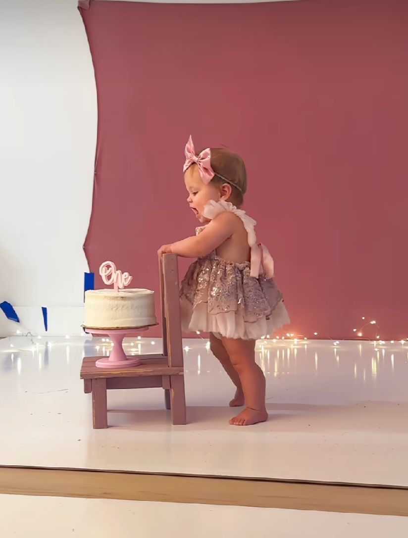 A young ballet dancer in a pink tutu performs graceful movements during practice in a dance studio.