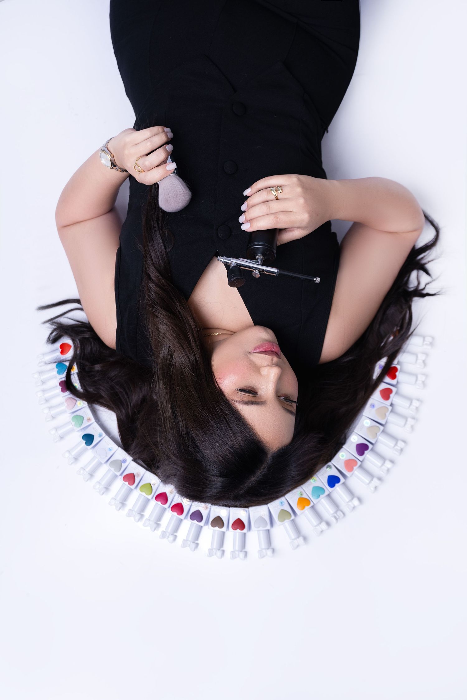 Artistic overhead beauty shot with hair products arranged in circular pattern.