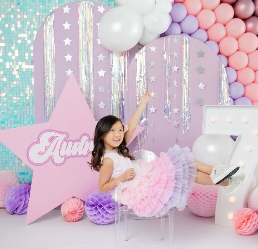 Pastel balloon arch with stars and dreamy decorations in pink, purple, and mint green colors.