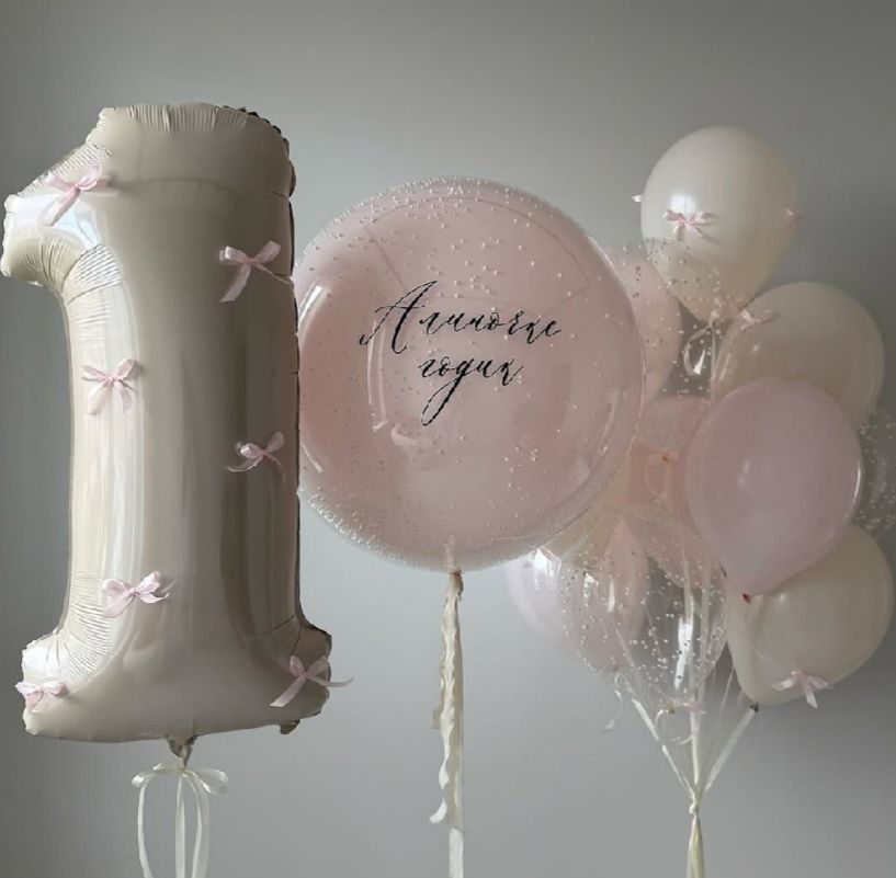 Pink and white balloon arrangement featuring a large number 1 balloon and a translucent round balloon with elegant text.