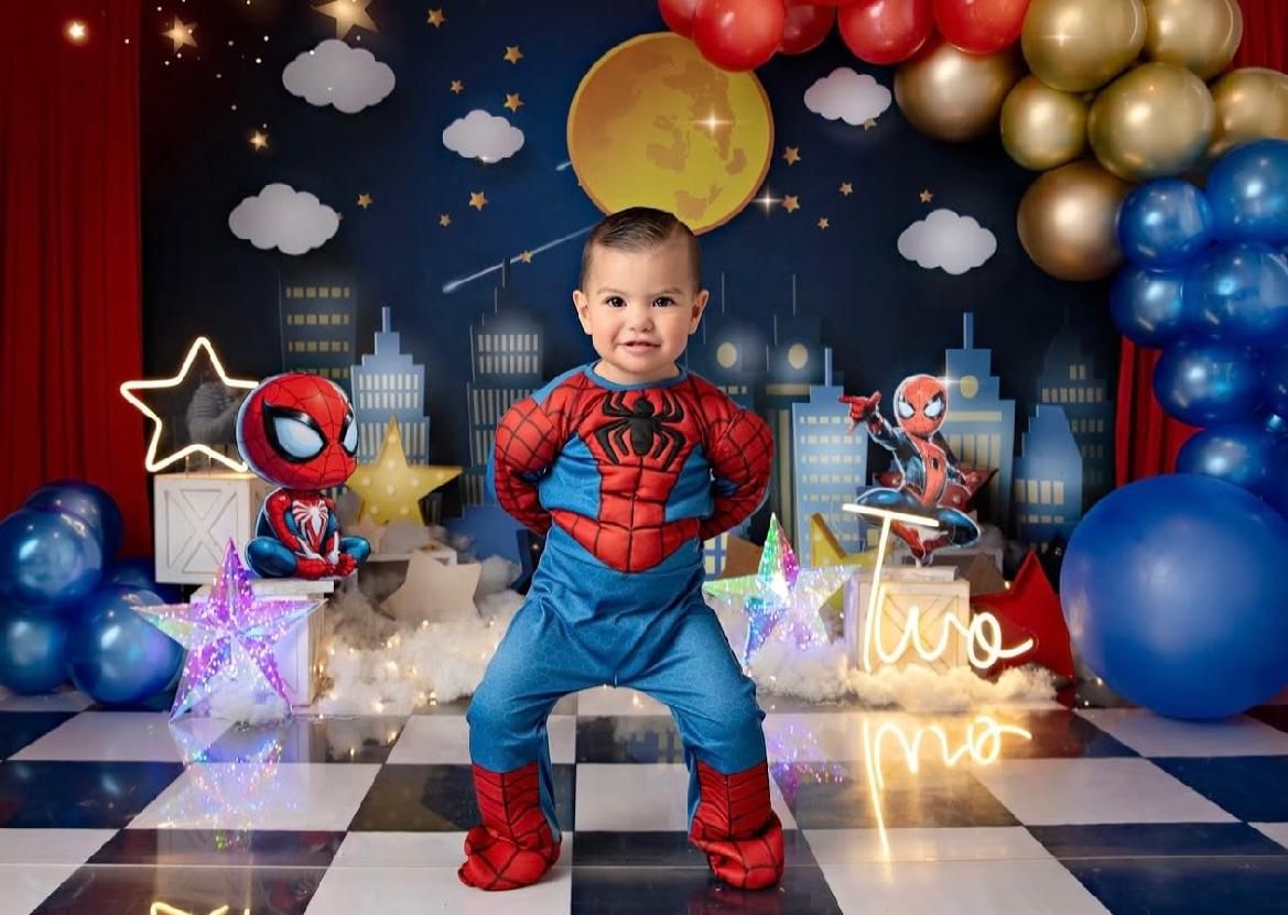 A superhero-themed party setup with balloons, city backdrop, and glowing decorative elements.