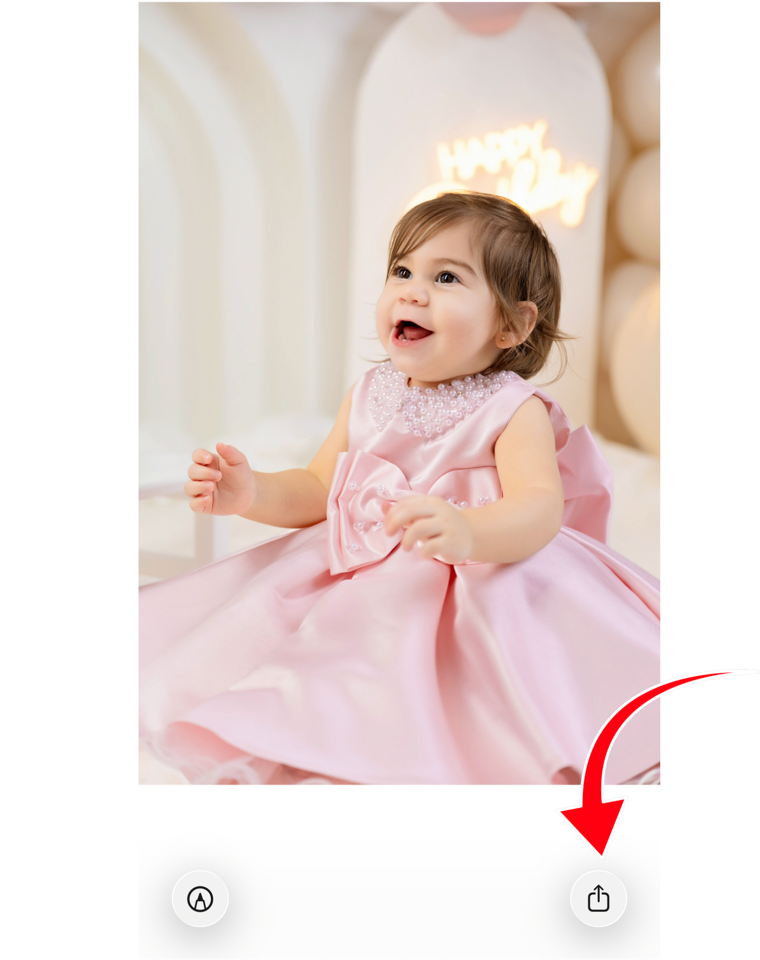 Adorable baby girl in a pink satin bow dress, laughing joyfully during a first birthday photo session.