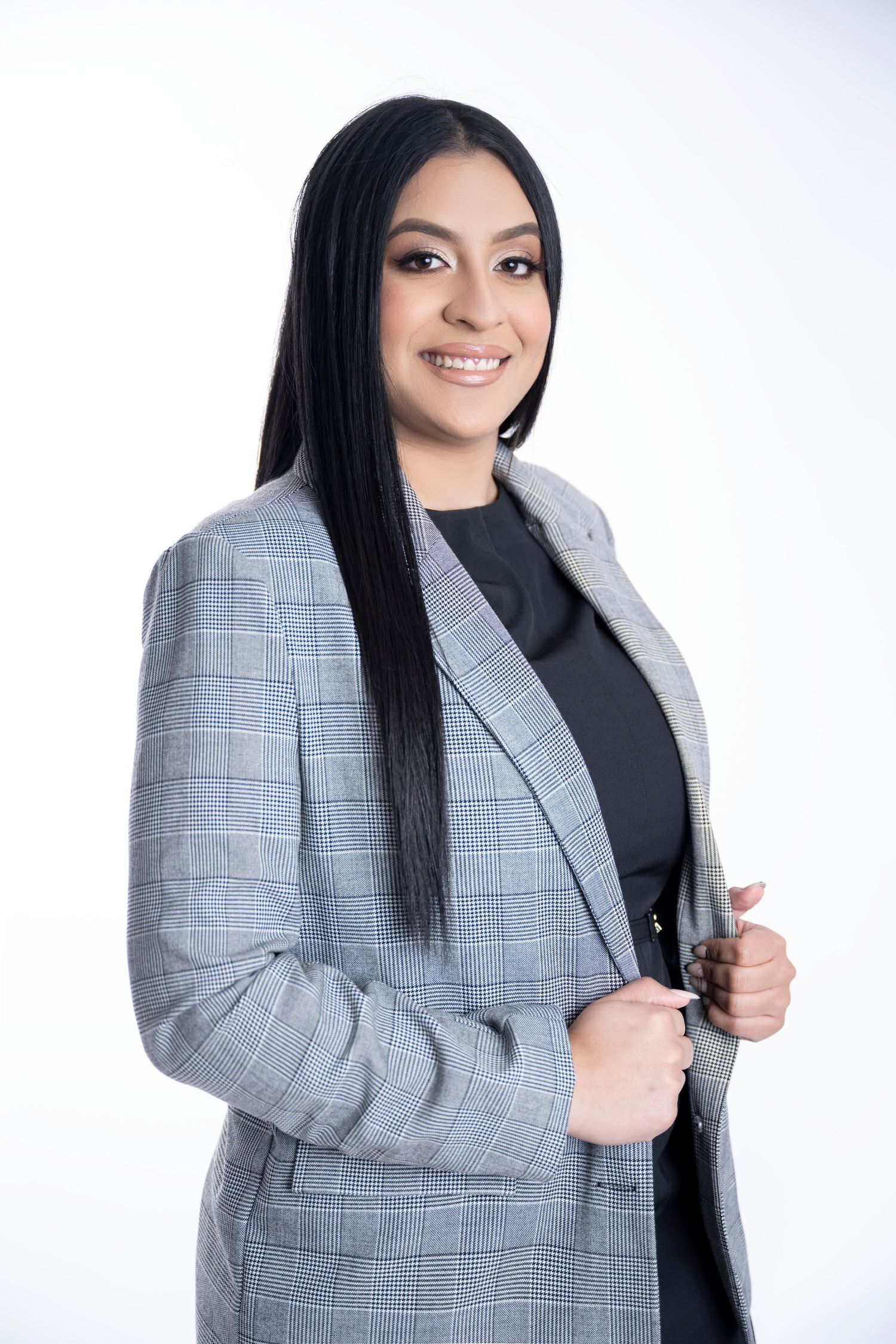 Business portrait in plaid blazer and black top against white background.