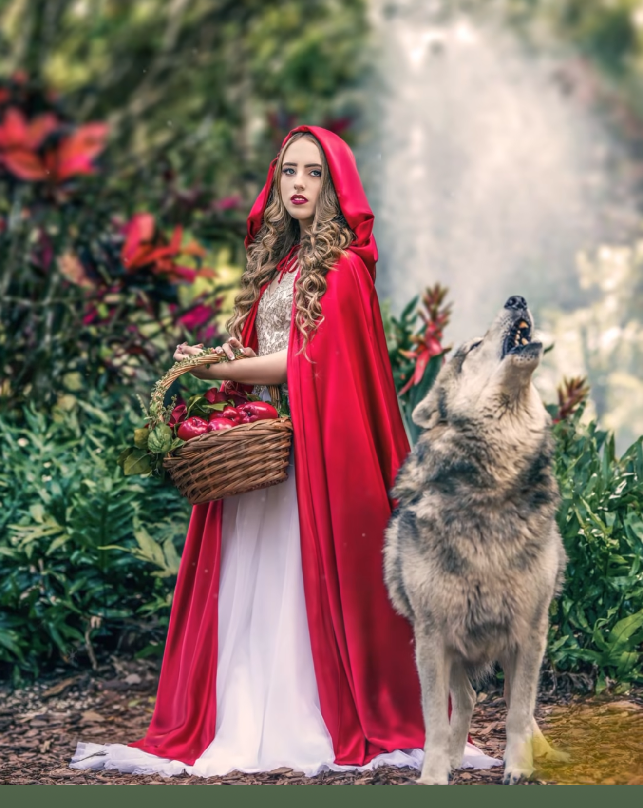 Woman dressed as Little Red Riding Hood with red cape and basket stands beside a howling wolf in an enchanted forest.