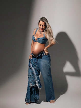 A maternity photoshoot sequence showing a person in denim against a white background with dramatic shadows.