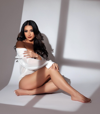 Artistic boudoir photo series showing a woman in white fabric posing against a minimalist backdrop with dramatic shadows.