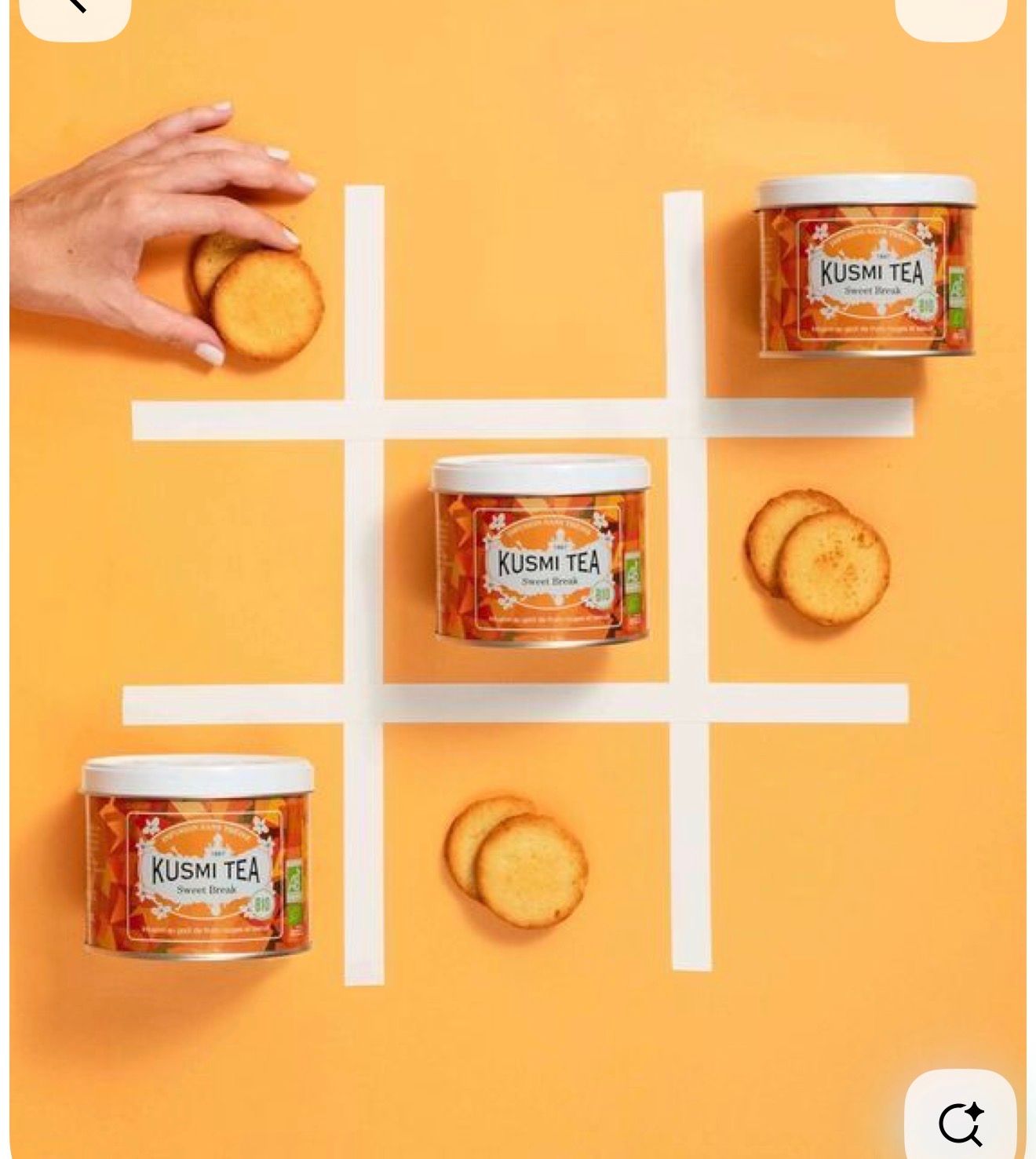Kusmi Tea tins arranged in a tic-tac-toe grid with golden cookies on an orange background.