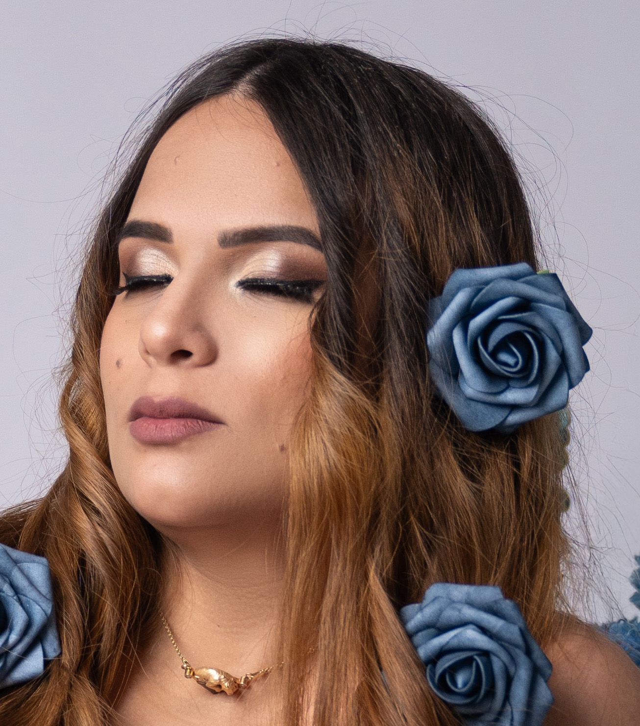 A beauty portrait with blue roses and dramatic eye makeup.