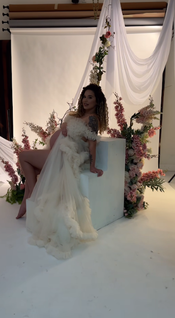 A series of photos showing someone in a flowing white wedding gown twirling and posing in a studio with floral decorations.