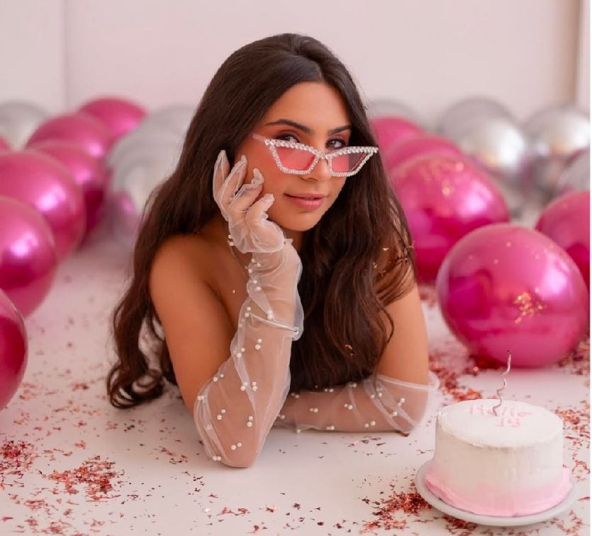 Pink and silver balloon decorations with birthday cake setup for glamorous party photography.