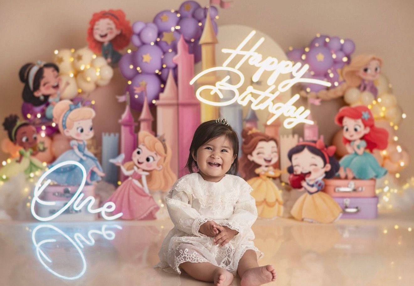 Baby girl smiles at Disney Princess themed first birthday party with colorful decorations and Happy Birthday neon sign.
