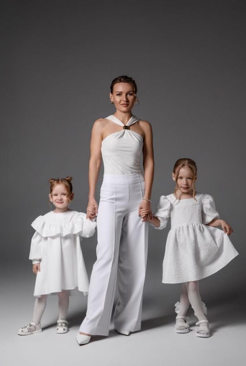 A series of photos showing children in white dresses and outfits against a gray studio backdrop.