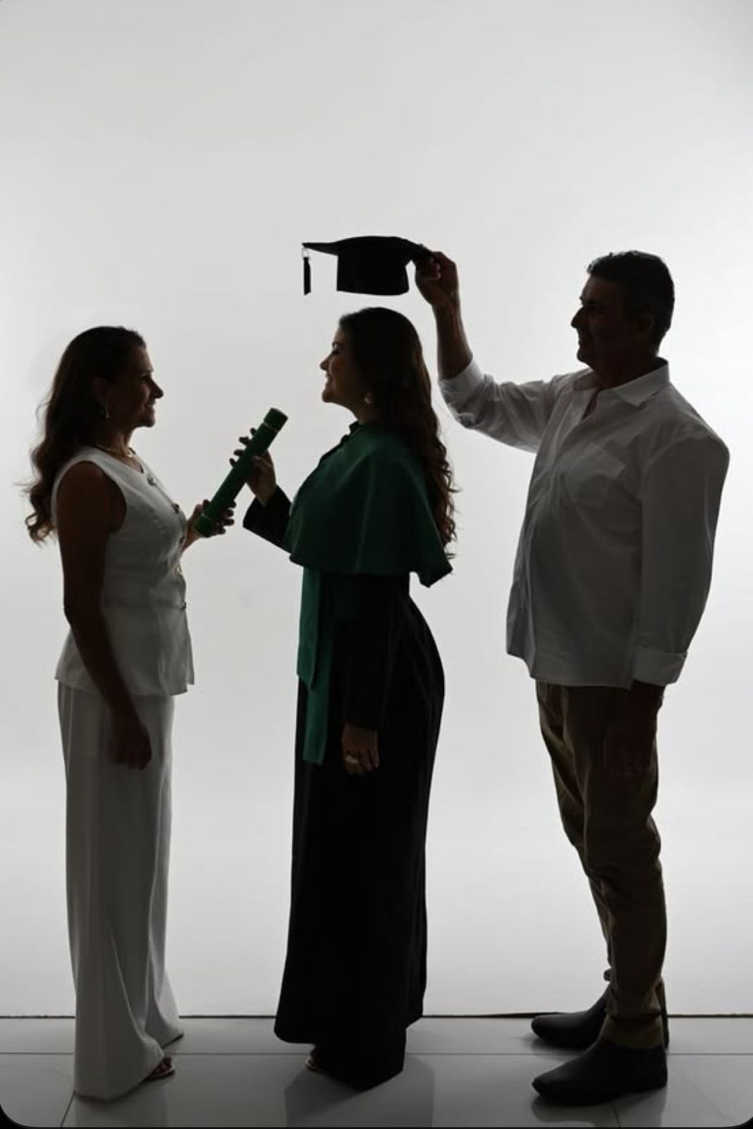 Silhouettes of people in white and dark clothing standing in a line against a light background.